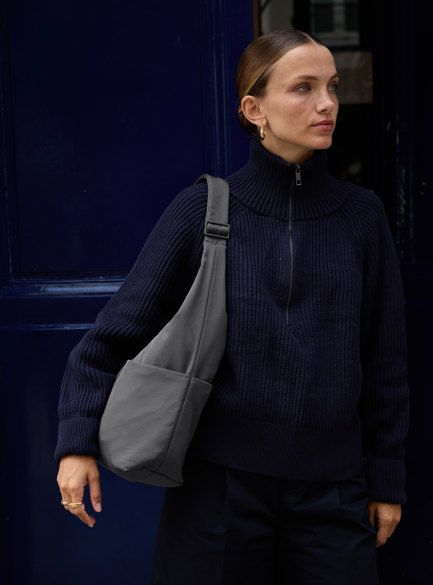 Woman carrying the Midi Arc slouchy hobo bag in dark grey nylon as shoulder bag